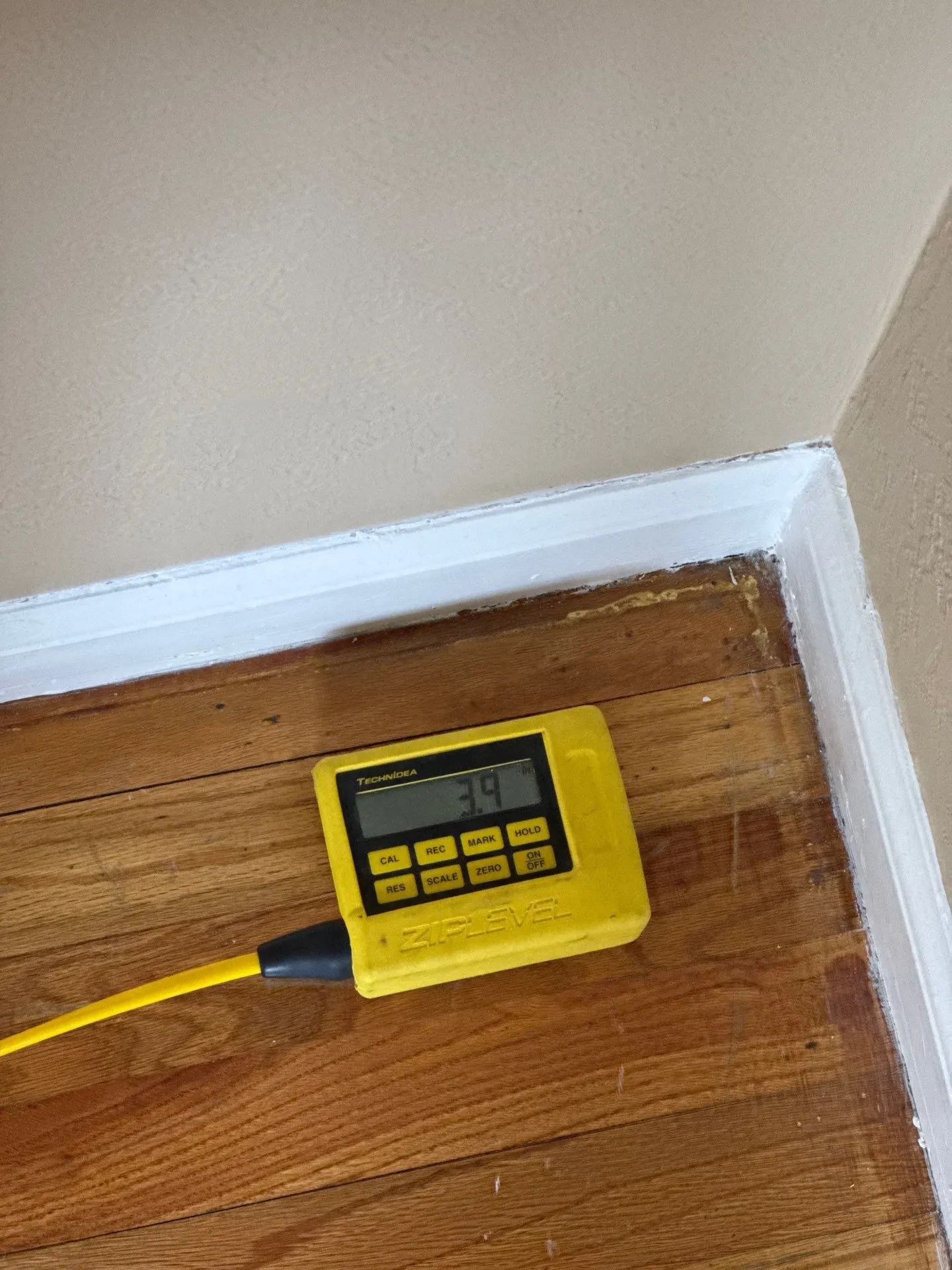 "Zip Level measuring floor elevation during foundation inspection to detect settlement in home."