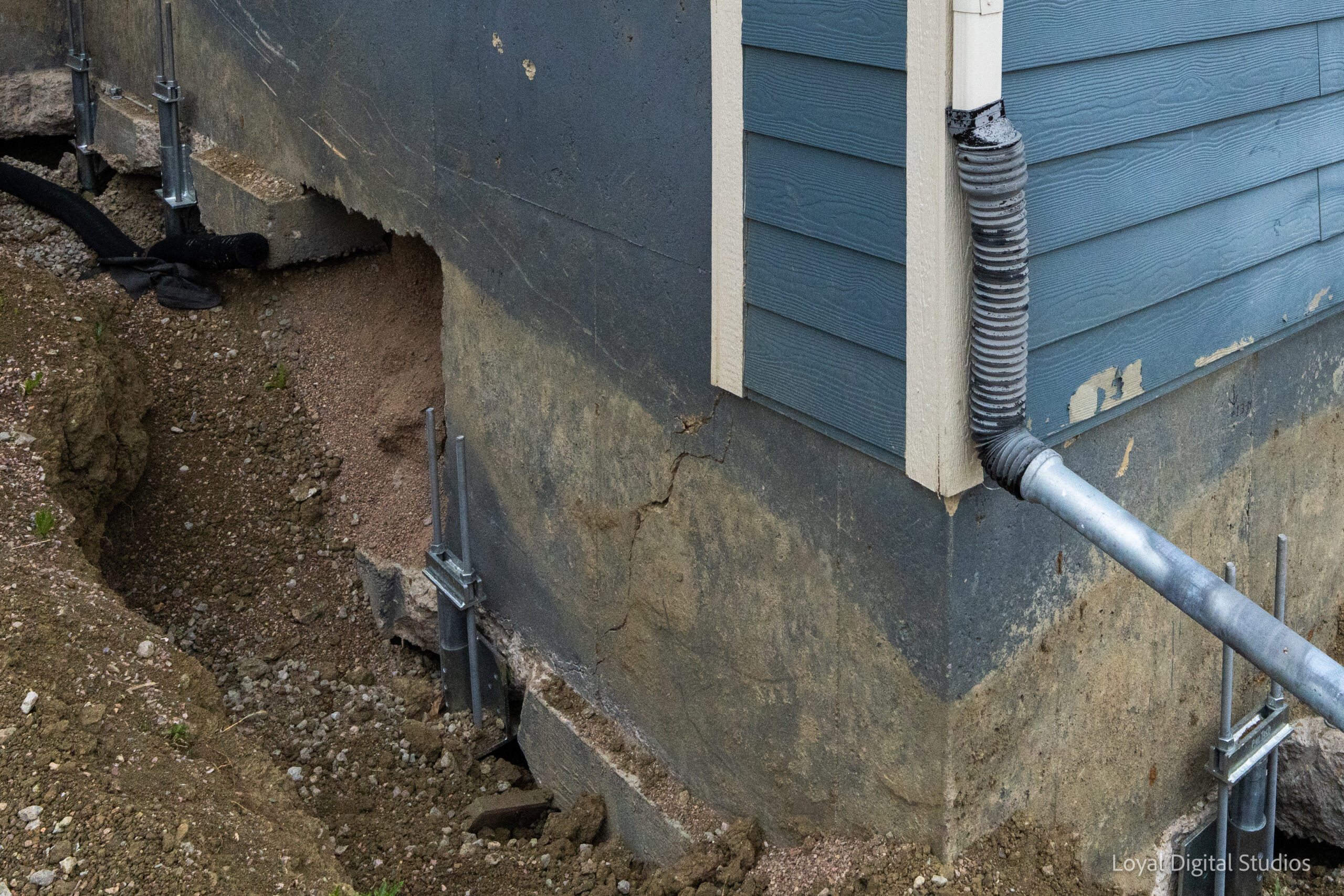 Exterior foundation stabilization with push pier installation on a settling Colorado home.