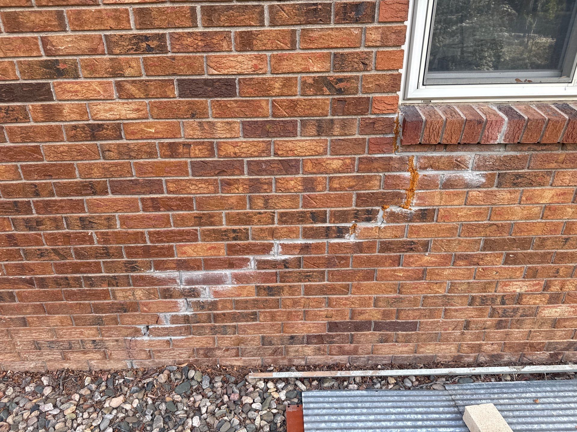 Stair-step brick foundation crack caused by foundation settlement on a Colorado home.