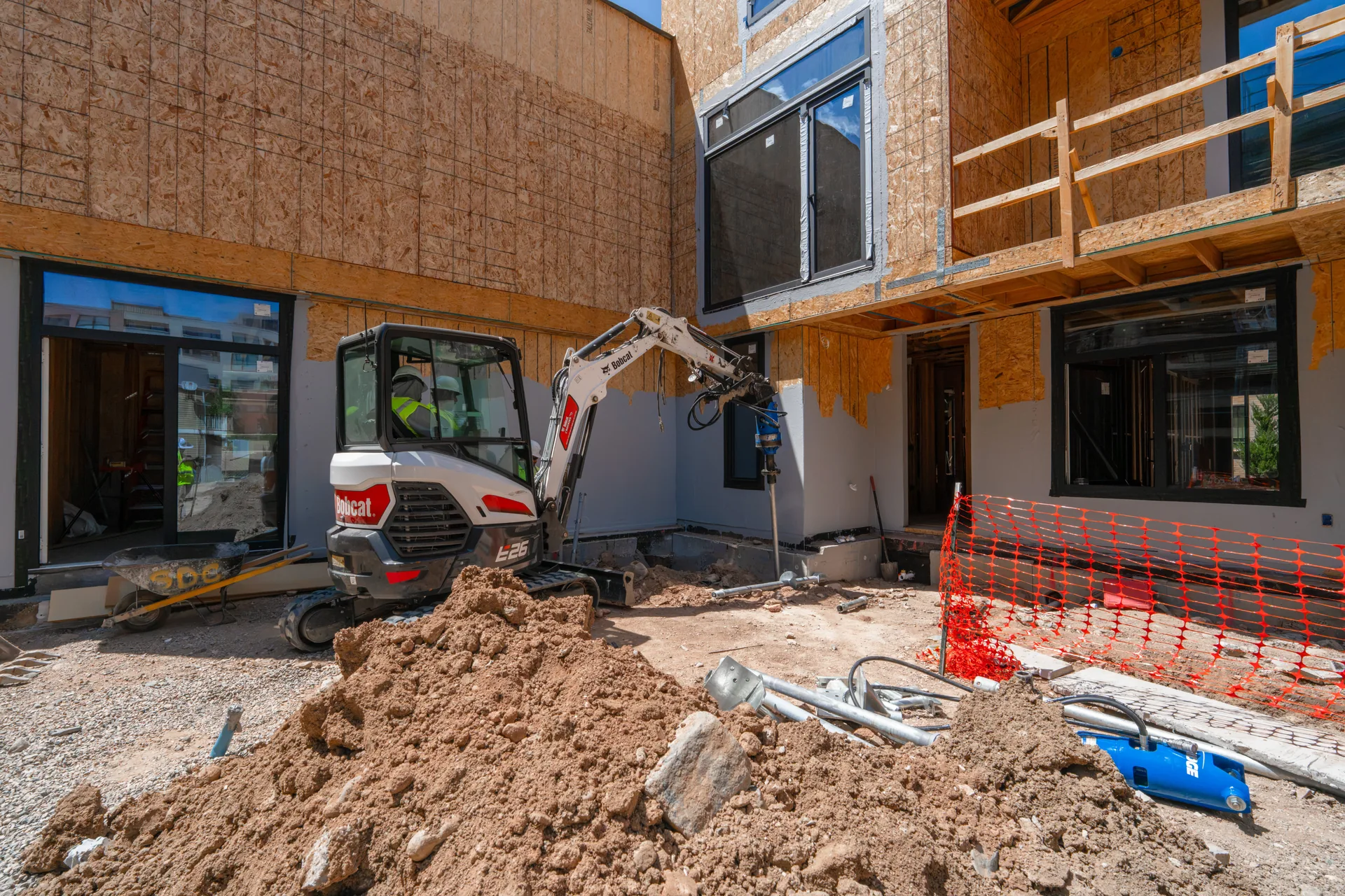Fort August Foundation crew performing commercial foundation repair and helical pier preparation with compact equipment at an ongoing project in Fort Collins Colorado.