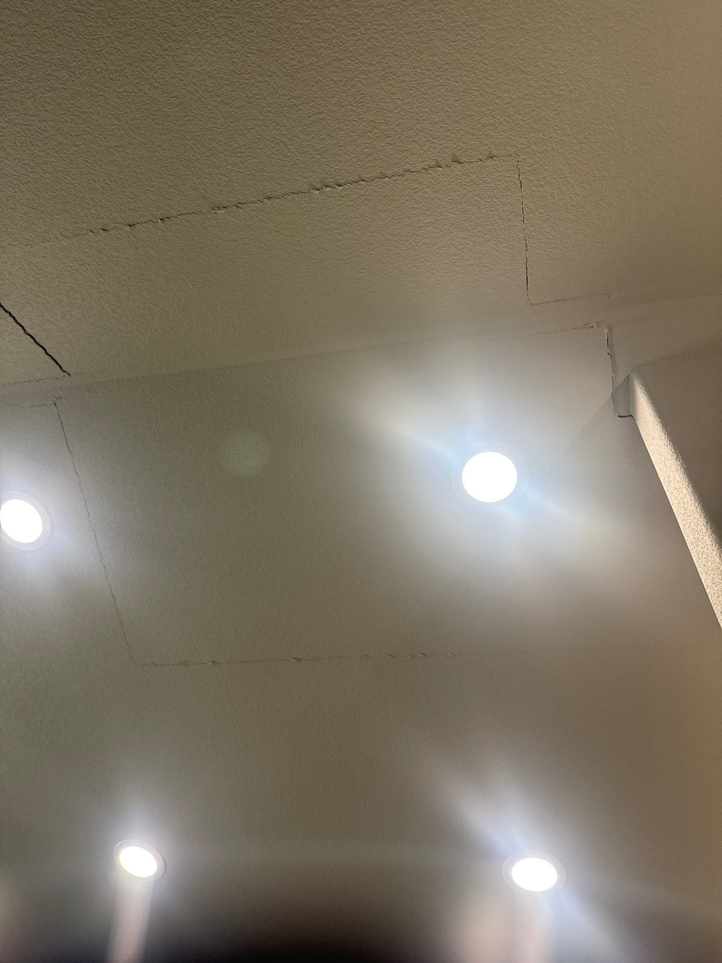 Cracking along drywall ceiling seams and a corner joint, consistent with foundation instability, in a home in Colorado Springs, Colorado.