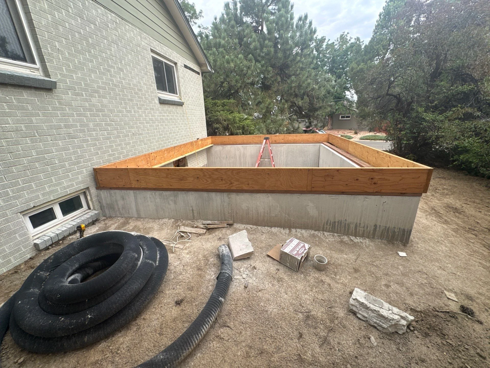 Newly poured concrete foundation walls with perimeter formwork at a Wheat Ridge new foundation construction project by Fort August Foundation.