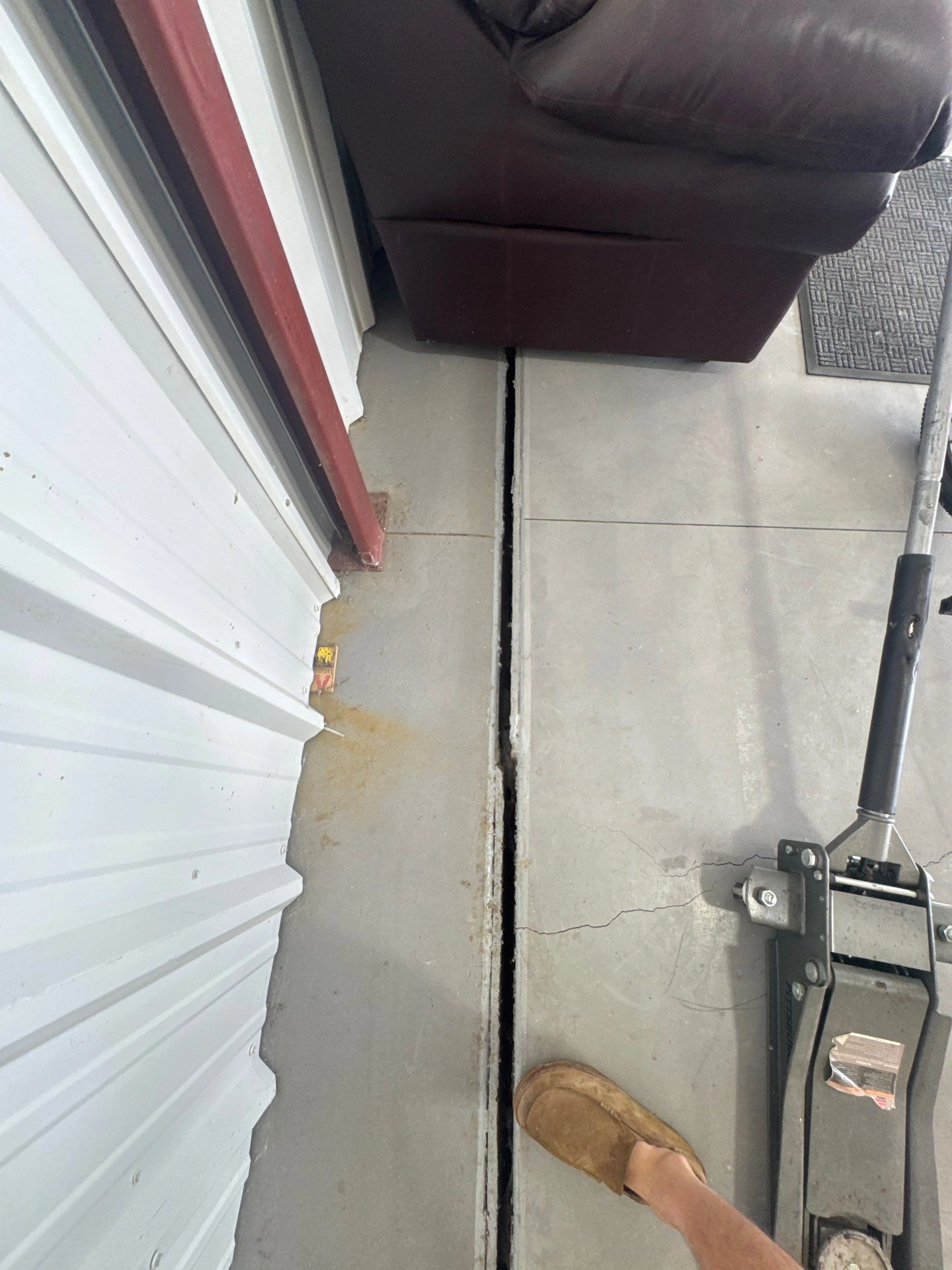 Visible gap between concrete floor sections and nearby crack during a foundation inspection in Loveland by Fort August Foundation