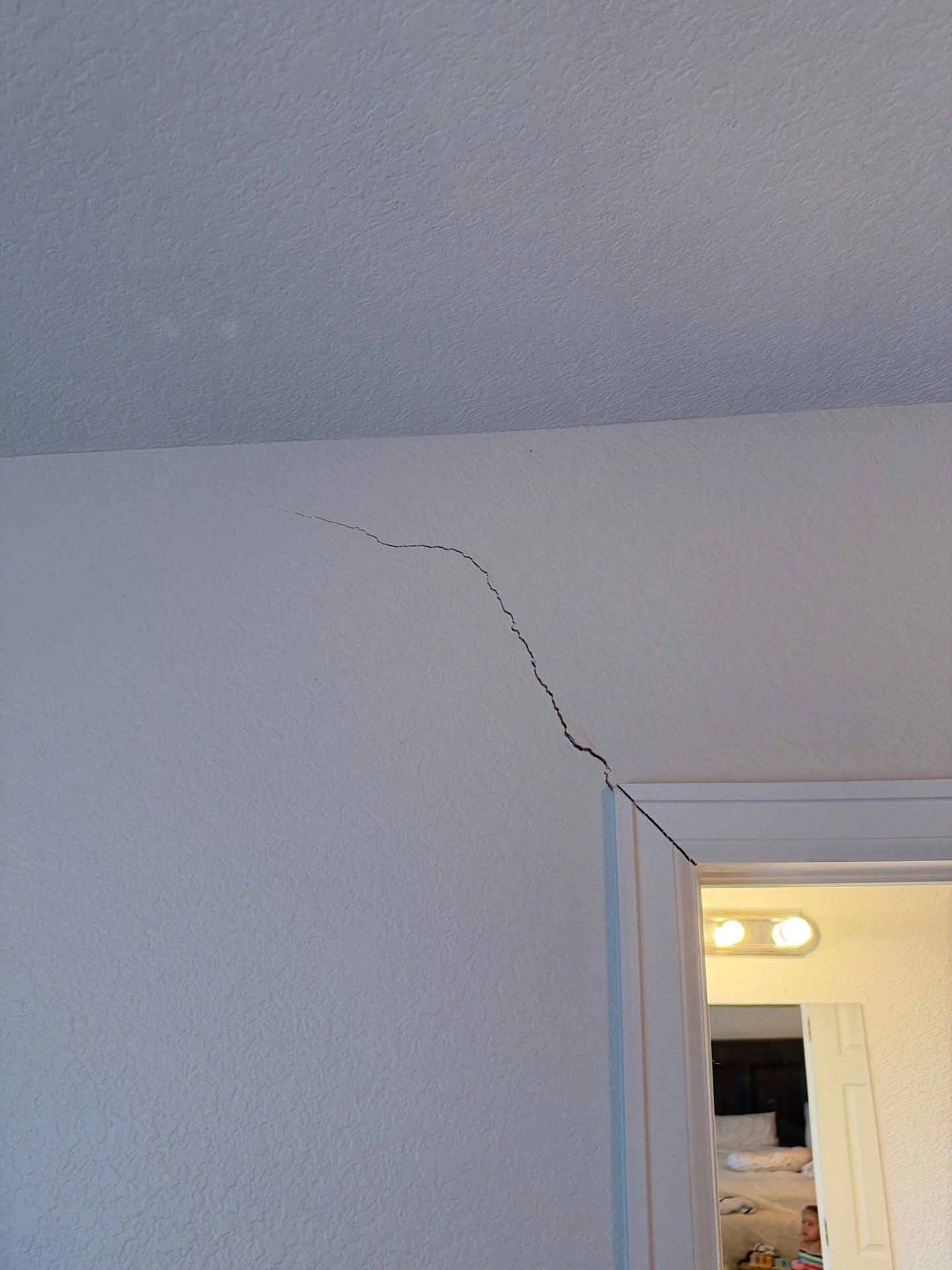 Drywall crack above an interior doorway documented during a foundation inspection in Pueblo